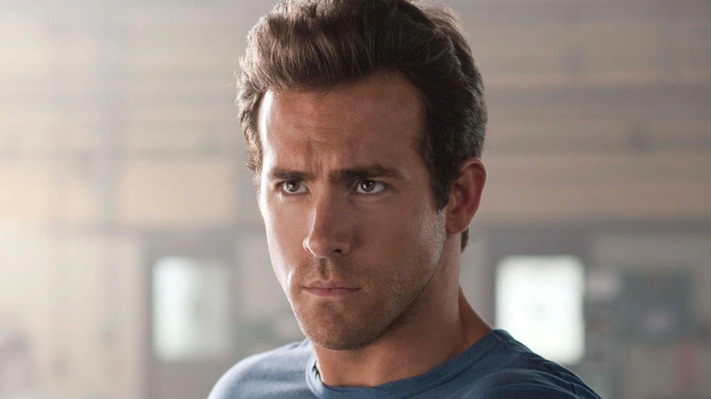 Ryan Reynolds as Hal Jordan with the Power Ring floating above his hand in Green Lantern