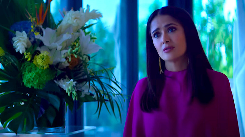 Salma Hayek Pinault stands next to a vase of flowers in Magic Mike's Last Dance