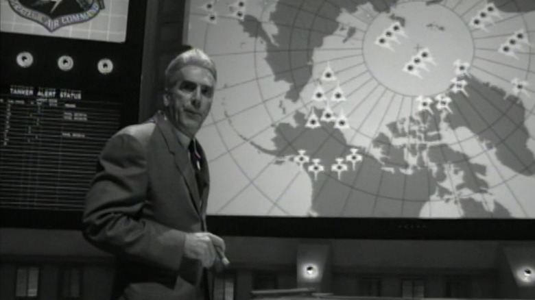 Sam Elliott's Congressman Raskob stands in front of a map showing the flight paths of bombers in Fail Safe