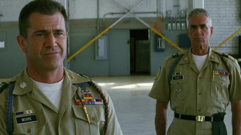 Mel Gibson's Lt. Col. Hal Moore stands in an air hanger as Sam Elliott's Sgt. Maj. Basil Plumley stands behind him in We Were Soldiers