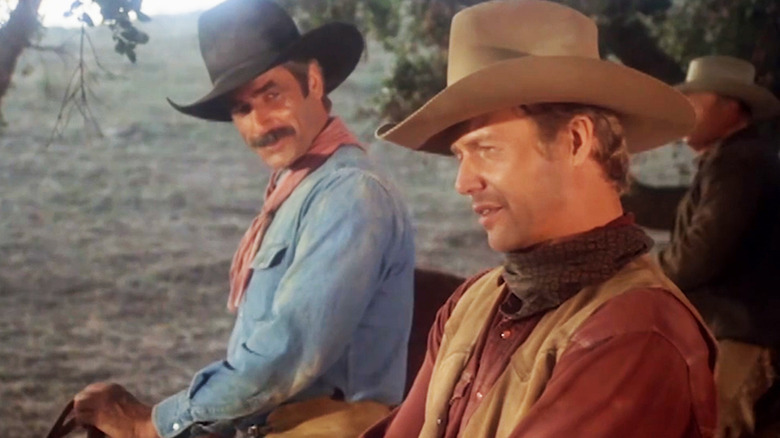 Sam Elliott's Chance McKenzie looks over at David Soul's Roy Champion as they sit on horses in The Yellow Rose.jpg