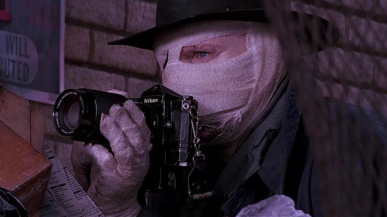 Peyton Westlake aka Darkman holding a camera with his face wrapped in bandages in Darkman