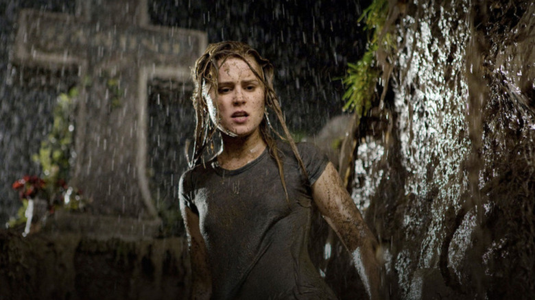 Christine Brown standing in a rainy graveyard covered in mud in Drag Me To Hell