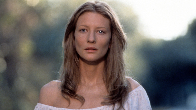 Annabelle "Annie" Wilson with long hair wearing a blouse off her shoulders outside in The Gift