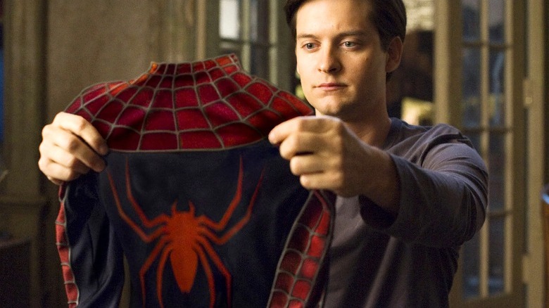 Peter Parker holding Spider-man costume