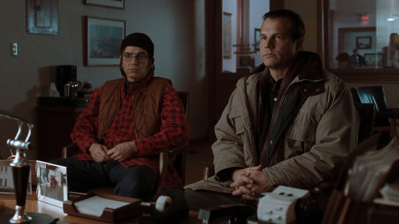 Billy Bob Thornton as Jacob Mitchell and Bill Paxton as Hank Mitchell sitting at a desk in A Simple Plan