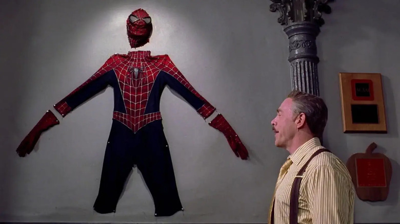 Spider-Man's suit pinned to a wall, with J. Jonah Jameson looking at it in Spider-Man 2