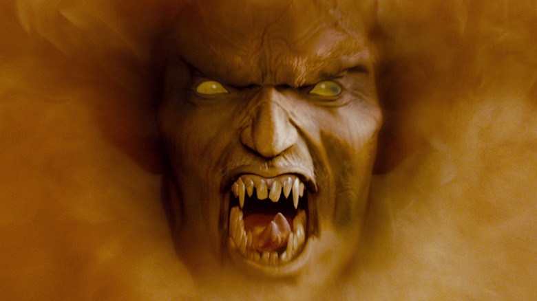 A yellow-eyed demon with sharp teeth surrounded by fire in Drag Me to Hell