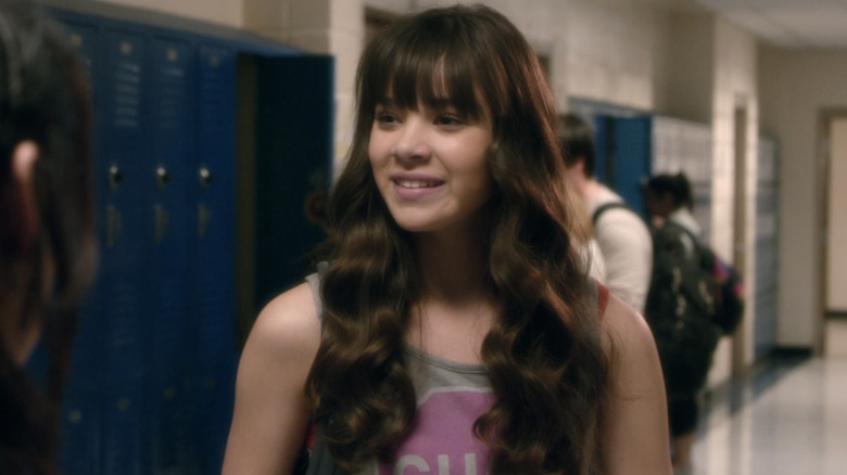 Hailee Steinfeld's Megan Walsh stands in a high school hallway smiling in Barely Lethal
