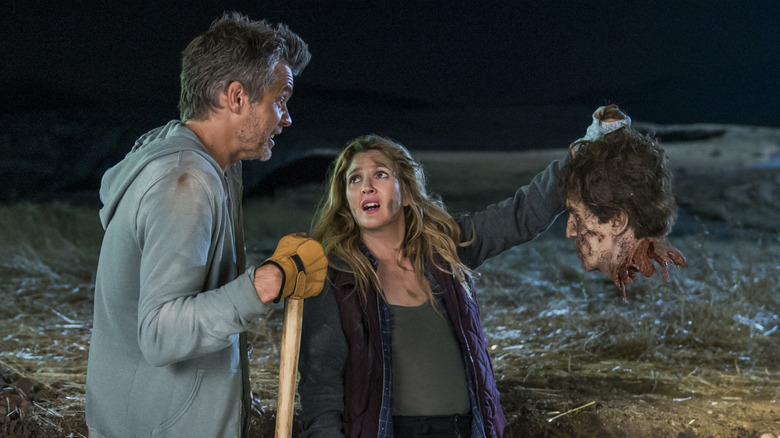 Joel and Sheila looking at a severed head
