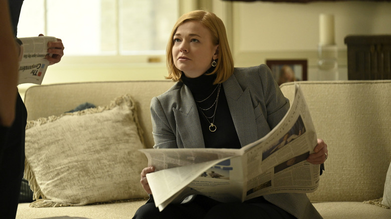 Shiv kijkt op van een bank en leest de krant over opvolging