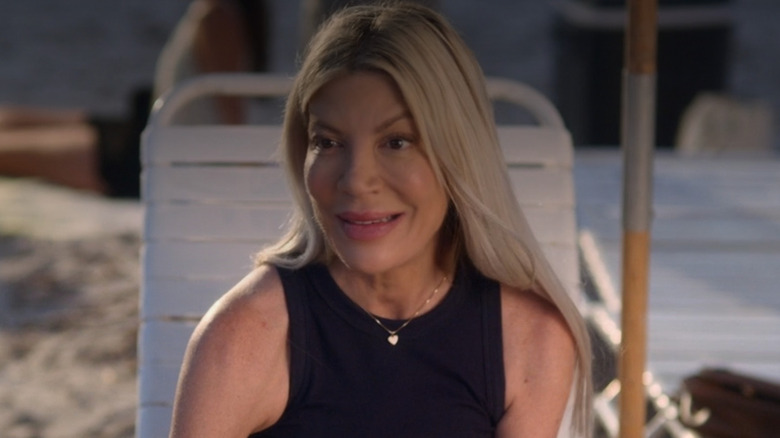 Tori Spelling as Beverly sitting in a beach chair smiling in Abducted in the Everglades