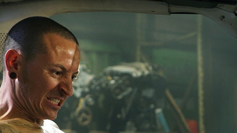 Chester Bennington as Evan chained to a car in Saw 3D