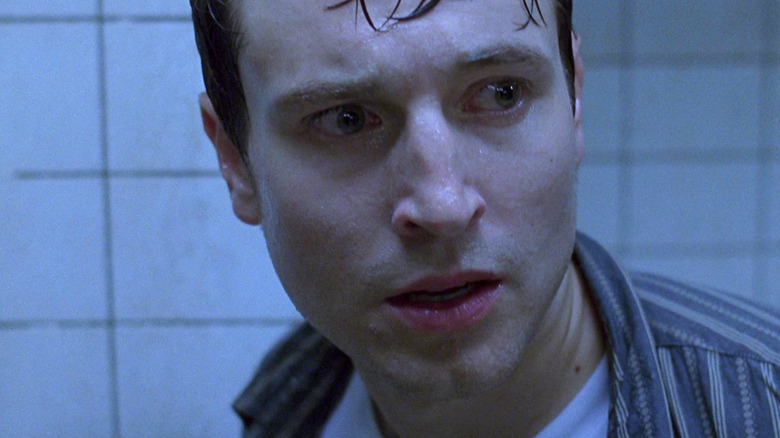Leigh Whannell as Adam looking damp and scared in Saw