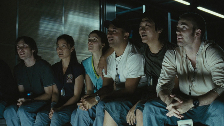 The crew of the Icarus II sitting together, smiling in Sunshine