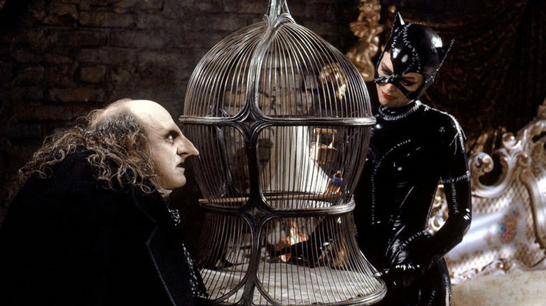 Penguin and Catwoman with a bird in a cage