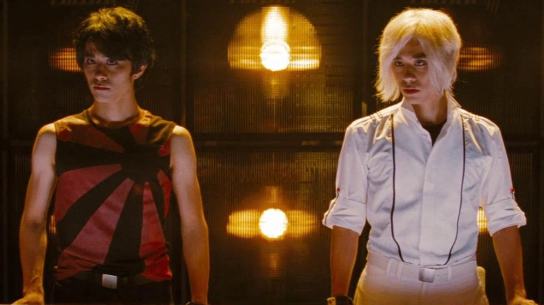 Keita Saito as Ken Katayanagi and Shota Saito as Kyle Katayanagi looking to the left in front of a wall of lights in Scott Pilgrim vs. The World