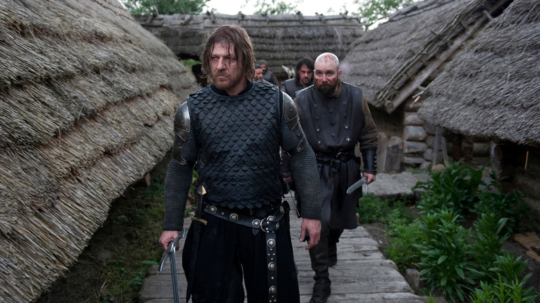 Sean Bean as Ulric leads a team of soldiers through a Medieval village in Black Death