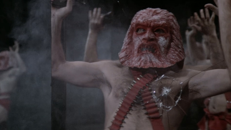Sean Connery's Zed stands shackled with a mask on in Zardoz