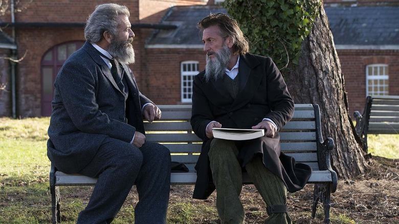 Sean Penn sits with Mel Gibson on bench