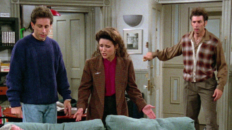 Jerry Seinfeld as Jerry, Julia Louis-Dreyfus as Elaine, and Michael Richards as Kramer staring at Jerry's couch in Seinfeld