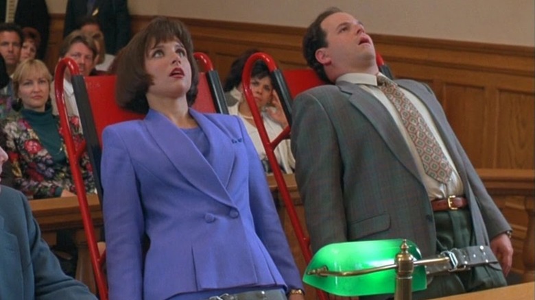 North's Mom (Julia Louis-Dreyfus) and North's Dad (Jason Alexander) lie comatose with their mouths open, strapped to red dollies in the middle of a courtroom in North