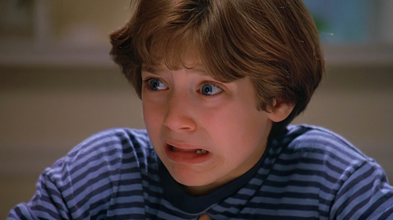 A close-up of North (Elijah Wood) wearing a striped shirt with a panicked expression in North