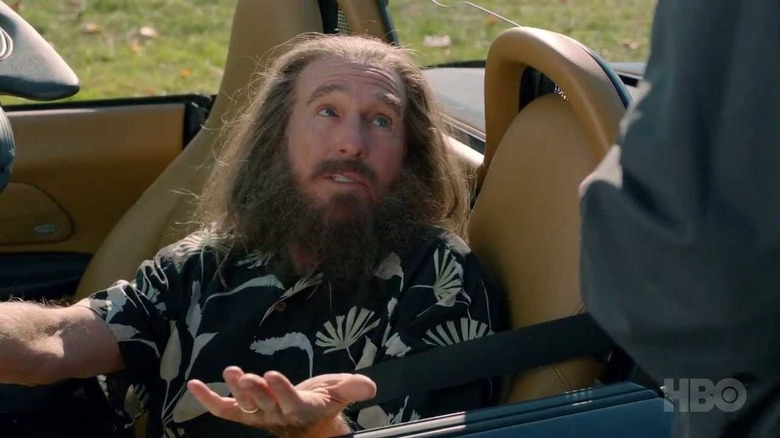 Nathan Flomm, dressed in a Hawaiian shirt, sits in the drivers seat of his sports car while looking up at the Police Officer just off screen who pulled him over in "Clear History"
