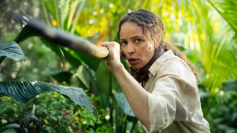 Linda Liddle holds a spear in the jungle in Send Help