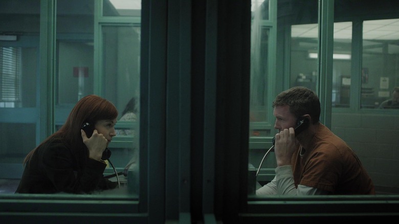 Britt Lower as Rachel Mills and Sam Worthington as David Burroughs having a conversation via phone in prison in I Will Find You
