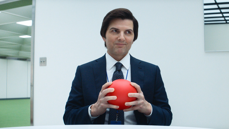 Mark S. holding a red ball and smirking on Severance