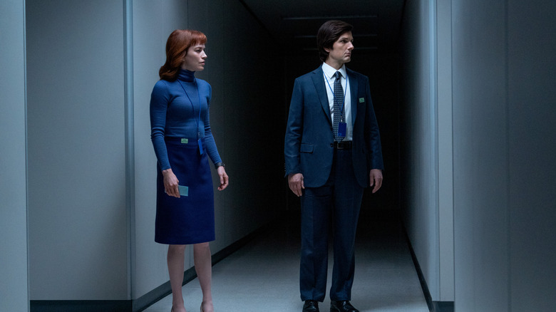 Helly and Mark standing in a dimly lit hallway at Lumon Industries