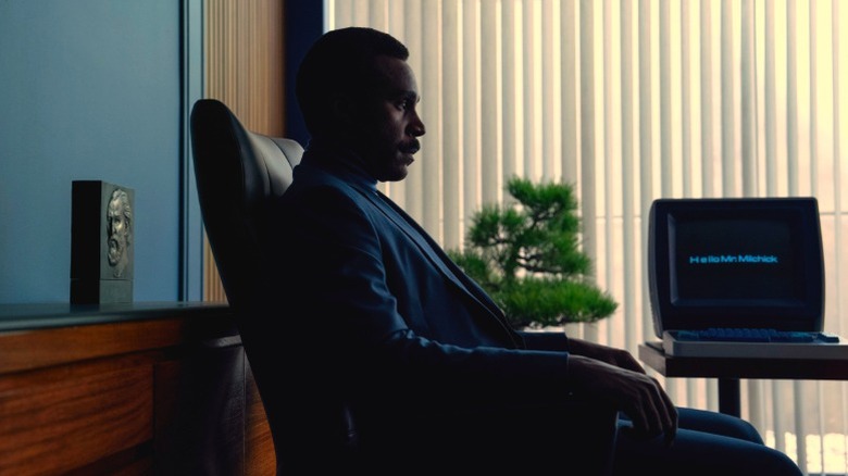 Seth Milchick de Trramell Tillman is sitting in an office chair in Severance