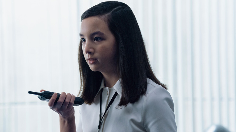 Sarah Bock's Miss Huang holding a walkie-talkie on Severance