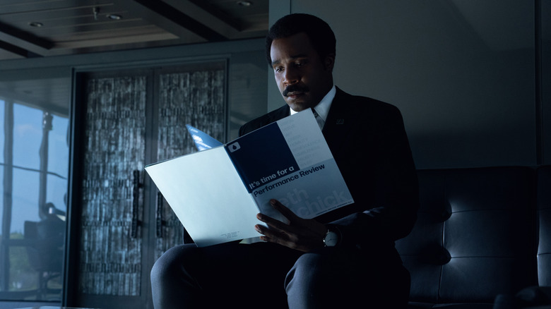 Milchick reading the performance review booklet on Severance