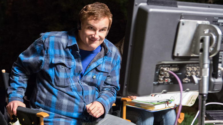 Shane Black sitting next to a monitor on the set of The Nice Guys