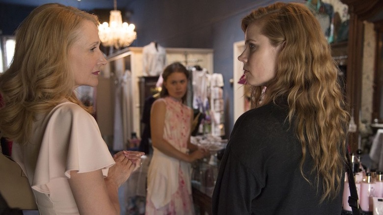 Adora and Camille looking at each other with Amma in the background on Sharp Objects