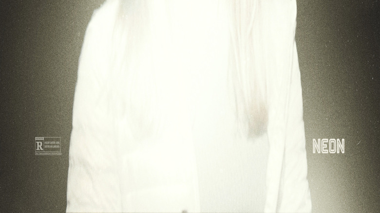 Sarah Durn as Riley distorted by light in the darkness on the poster for Shelby Oaks