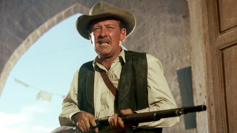 William Holden holding a gun in The Wild Bunch