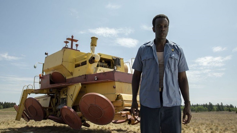 A man stands in a field in front of his hover-tractor