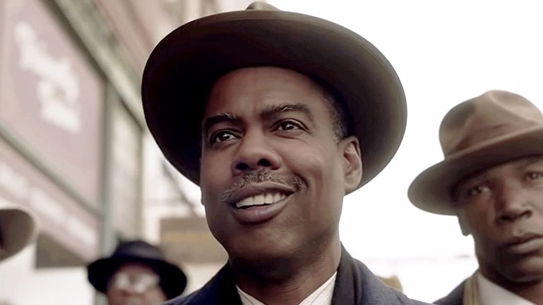 Chris Rock grinning in a hat