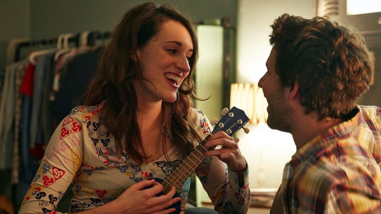 Phoebe Waller-Bridge smiles at a man while playing the ukulele