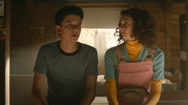 Asa Butterfield and Tanya Reynolds sitting on a bed