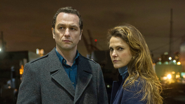 Matthew Rhys and Keri Russell standing around at night