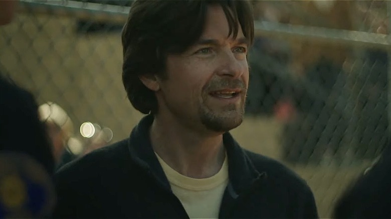 Jason Bateman in front of a fence