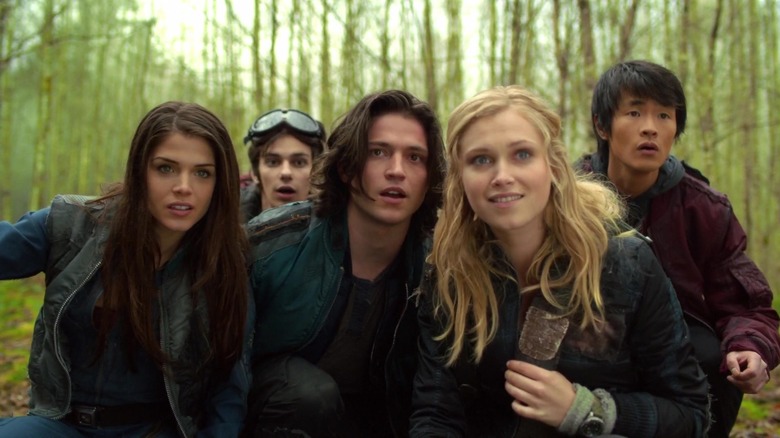 The 100 teens all looking at something in the woods