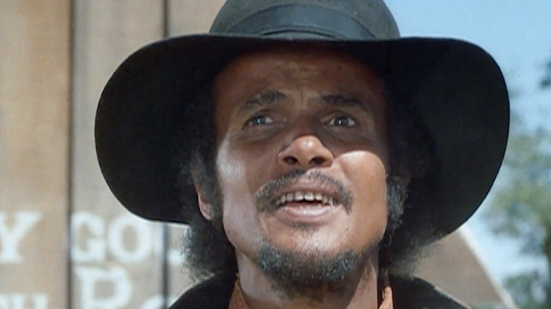 Harry Belafonte's Preacher is seen in closeup as he stands outside in Buck and the Preacher