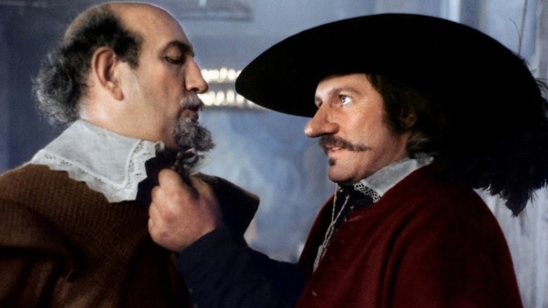 Cyrano holding the collar of a foe in Cyrano de Bergerac