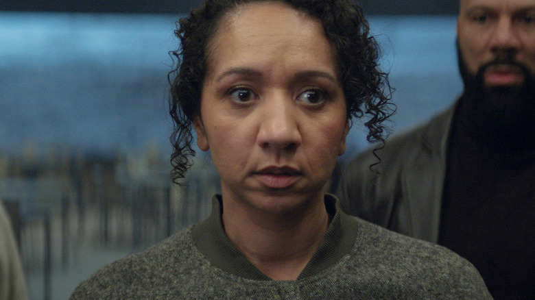 Camille looking dead inside as her husband looks at her in horror in Silo