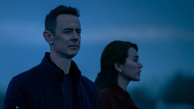 A tech billionaire and Helen look at something at dusk in Silo Season 3